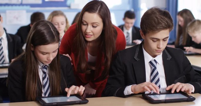 4k, young teacher spending some one-on-one time with her students during class.