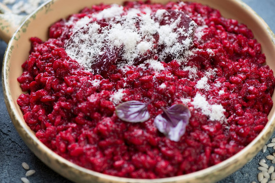 Close-up of risotto with beetroot and parmesan, selective focus, studio shot