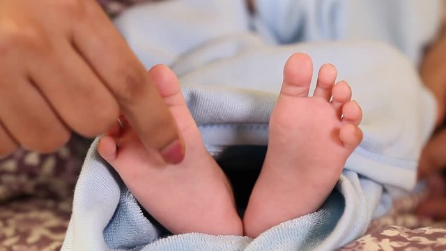 Newborn Baby's feet.Mother holding newborn baby leg for massage 