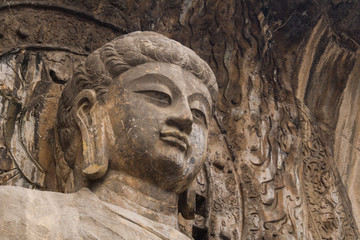 Fototapeta na wymiar Close-up The face Stone Buddha Statue Carved from the mountains.