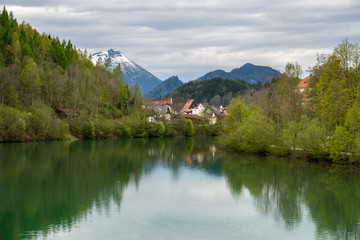Fototapeta na wymiar Fussen, romantic Bavarian city in Germany, reflective view on river.