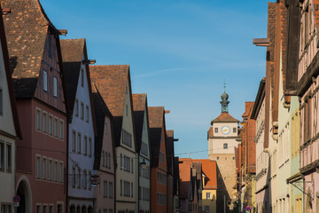Fototapeta na wymiar Colorful building and clock tower in old street of Rothenburg ob der Tauber, Bavaria, Germany.