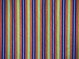 Fototapeta premium Colorful striped curtains cover window in hall. Wavy colorful fabric curtains