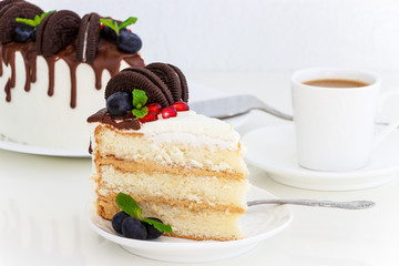 Piece of vanilla layer cake with fresh berries, cream cheese and chocolate biscuits. On white background. Romantic concept.