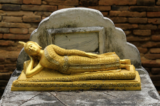 Old anceint Sleeping Buddha statue On the old brick wall is the background..,Lampang province, Thailand.