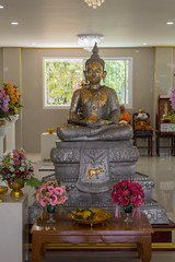 Buddha image sitting With flowers for worship.