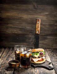 Street food. Big burger with cola and sauce.