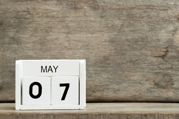 White block calendar present date 7 and month May on wood background