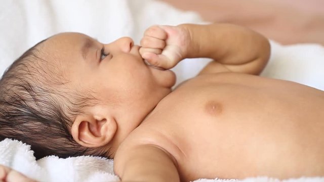 Newborn baby boy sucking his for soothing himself