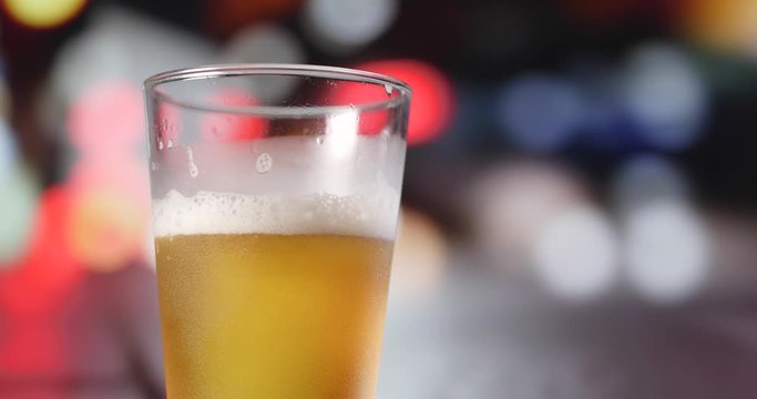 Pouring light beer into glass with drive car background