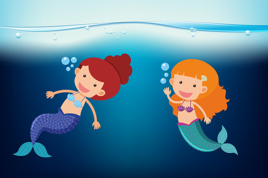 Two mermaids swimming under the sea