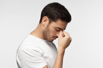 Fototapeta premium Young man crying about his failure, feeling bad about unpleasant situation. Negative emotion concept.