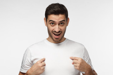 You talking to me? Young man pointing to himself with question if he did something wrong.