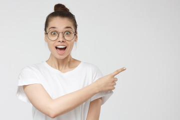 Horizontal picture of young good looking wooman isolated on grey background wearing big round...