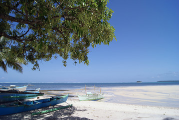 Seaside Scene with Outriggers by a White Beach