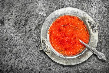 Red caviar in an old saucer.