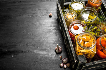 Preserves vegetables in glass jars in an old box.