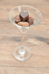 A variety of small chocolates displayed in a martini glass