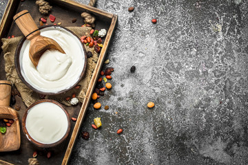 Natural yogurt with a scoop in a bowl.