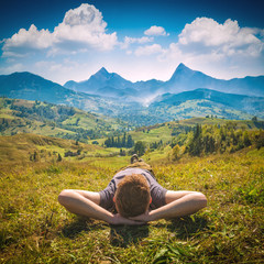 Young red hair man lying on a hill