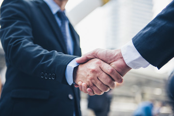 Fototapeta premium Business people shaking hands, Greeting Deal Concept, modern city background.