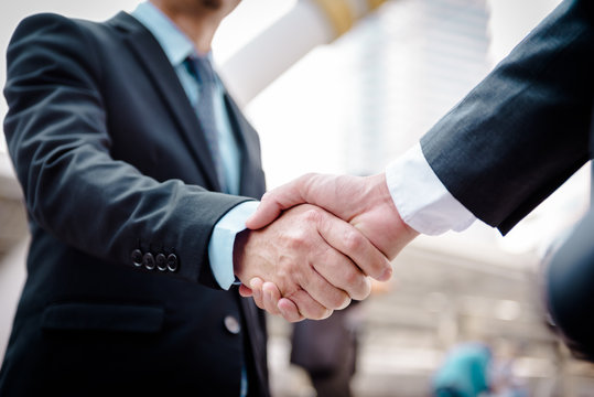 Business people shaking hands, Greeting Deal Concept, modern city background.