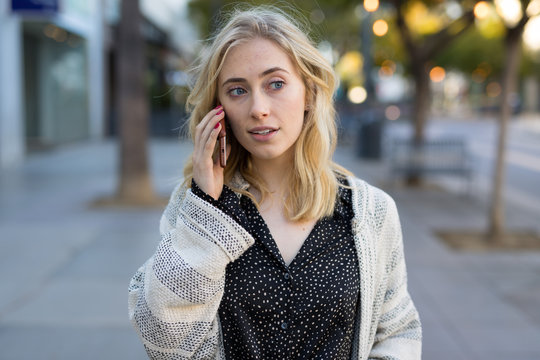 Young caucasian woman walking talking cell phone