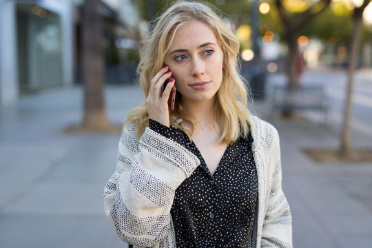 Young caucasian woman walking talking cell phone