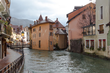 Fototapeta na wymiar Road, lights, Houses of different colours, doors, windows and bushes near the river in Annecy, France