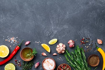 Photo sur Plexiglas Herbes Ingredients for cooking. Herbs and spices on black stone table top view. Food background.