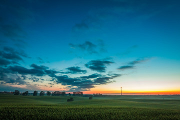 Fototapeta na wymiar Dusk over field wind turbines in summer, Europe