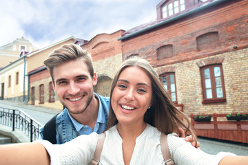 Fototapeta na wymiar Happy couple of tourists taking selfie in old city.