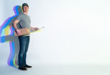 Full length portrait of happy courier with multicolored shadow holding package and clipboard in hands. Copy space. Service concept