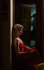 Fototapeta premium The girl in the red dress at the door