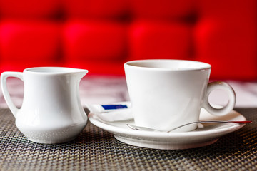 A cup of coffee and coffee beans on table with the backdrop of the light