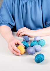 Woman holding the colored yellow easter egg