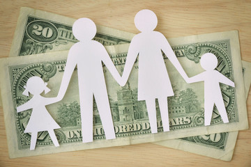Paper family cut-out on dollars banknotes - Family budget concept