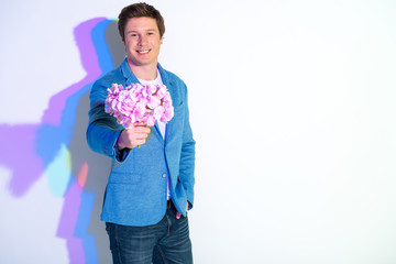 Portrait of happy male holding flowers. Copy space. Spring concept