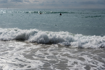 Foamy atlantic ocean wave on beach sand.