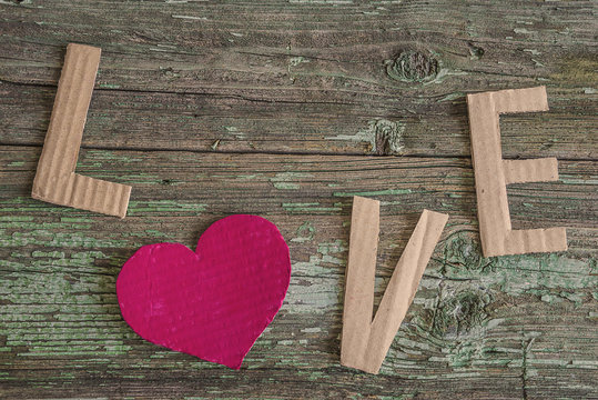 love letters and red heart on rustic painted background, sepia toned picture with selective focus