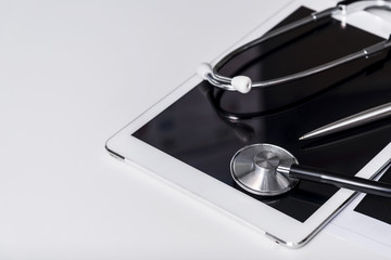 Health check concept. Medical tablet with stethoscope on white background with free copy space. Business checking.