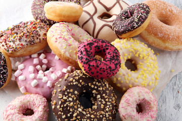 assorted donuts with chocolate frosted, pink glazed and sprinkles donuts.