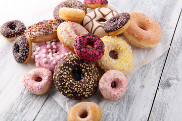 assorted donuts with chocolate frosted, pink glazed and sprinkles donuts.