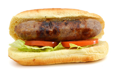 Grilled bratwurst on a bun and tomato, salad on white