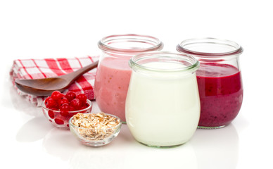 Delicious, nutritious and healthy yogurt in a glass jars with spoon on a white background