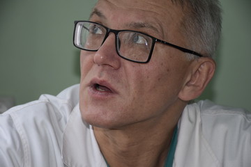 портрет украинского врача в очках,мечтает об отпуске  