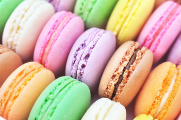 Colorful macarons on bright festive decor background, selective focus, toned