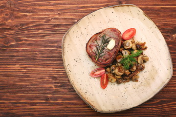 Tasty Beef steak with mushrooms and herbs on plate