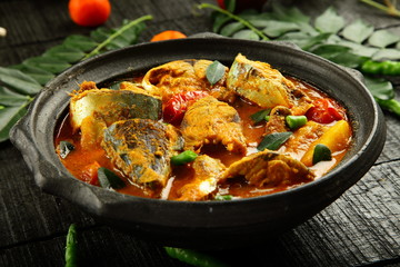 Fish curry served on a rustic wooden table,
