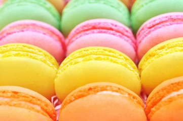 Colorful macarons on bright festive decor background, selective focus, toned